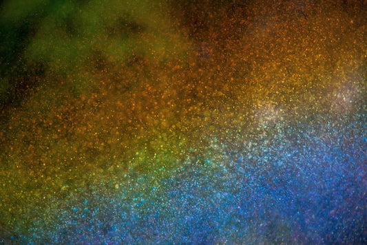Colorful abstract water droplets in a rainbow array, with a gradient from green to blue and brown.